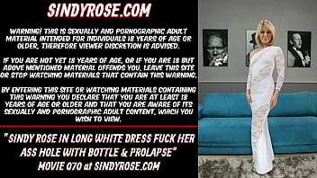 Sindy Rose in un lungo abito bianco si scopa il buco del culo con bottiglia e prolasso