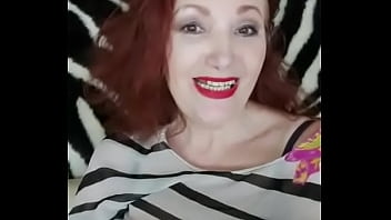 Red-haired lady shows her breasts in a white-black blouse