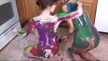 Two red-haired chicks erotically rub each other with colored paints on their slender bodies