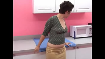 Sexy morena curvilínea usa um vibrador roxo na cozinha