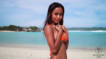 Putri Cinta stripping on a beautiful tropical beach